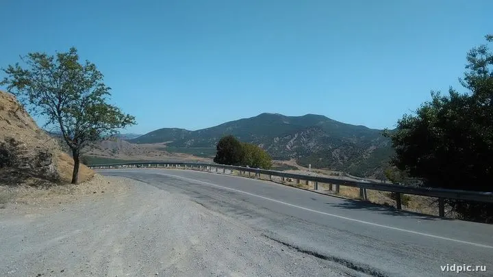 Empty mountain road with guardrail leading to the horizon. Perfect for travel and car advertising.