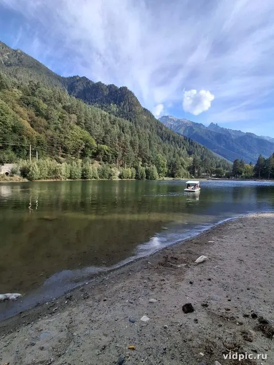 A tranquil lake at the foot of the mountains, surrounded by green forests. Perfect for nature relaxation.