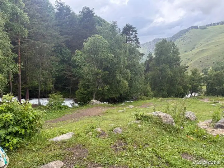 Green forest and mountains under cloudy sky — another angle. Landscape with green forest and mountains under cloudy sky. Карачаево-Черкесия, Россия